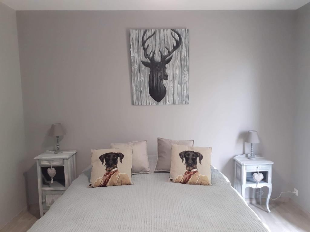 希特奈La Petite Salamandre的卧室配有一张挂着鹿图的床铺。