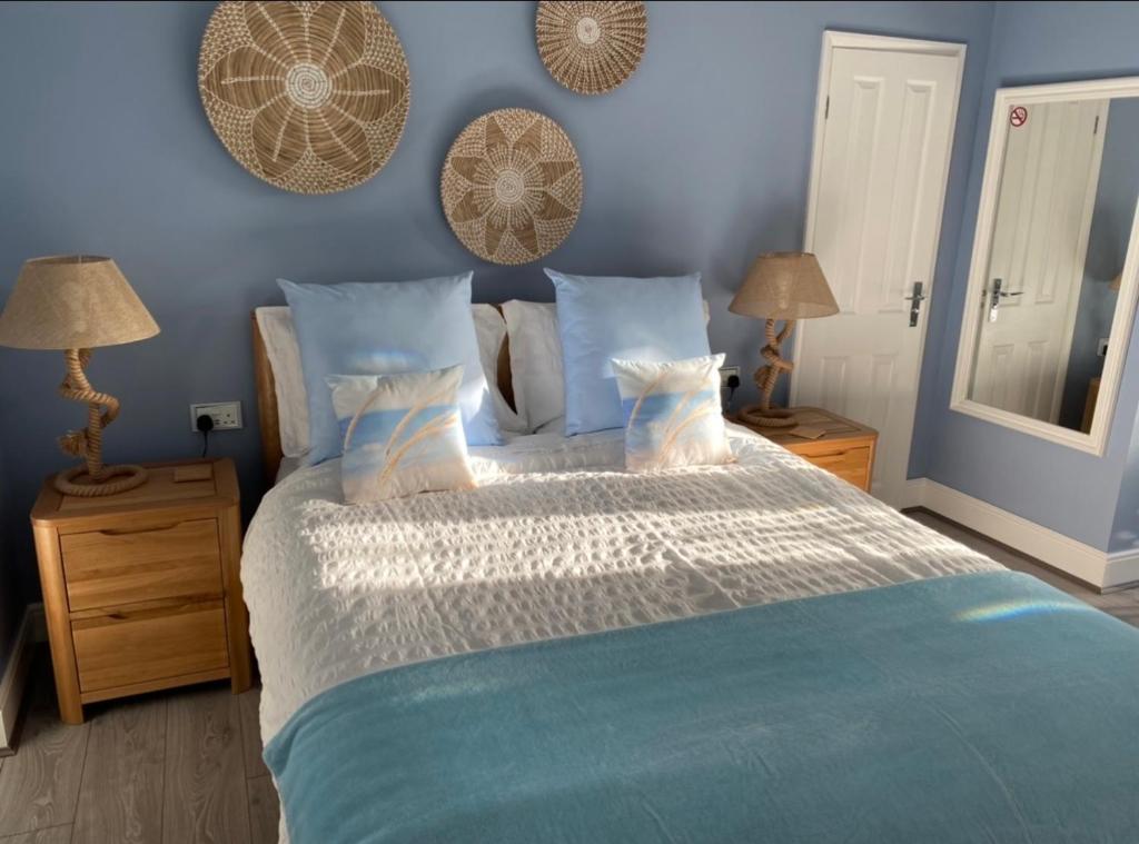 斯凯格内斯Sea Breeze Apartment Skegness的一间卧室配有一张带蓝色墙壁的大床