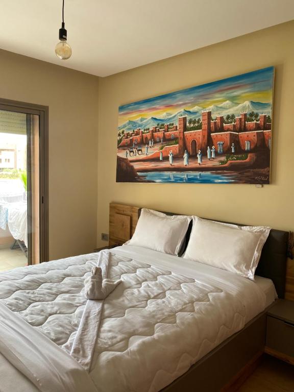 马拉喀什Prestigia Golf的卧室配有一张白色大床,墙上挂有绘画作品
