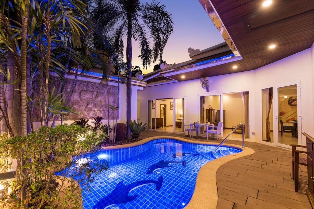 南芭堤雅Village Austria Luxury Pool Villas的一座带房子的后院的游泳池