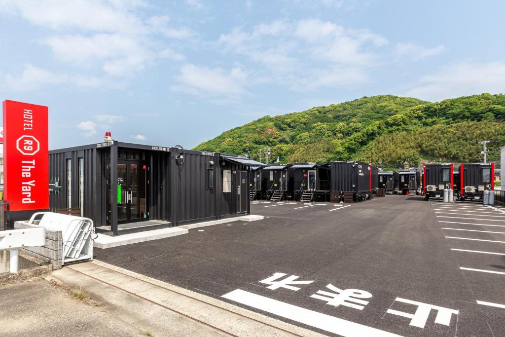 佐贺市HOTEL R9 The Yard Kohoku的停车场有一堆黑色拖车