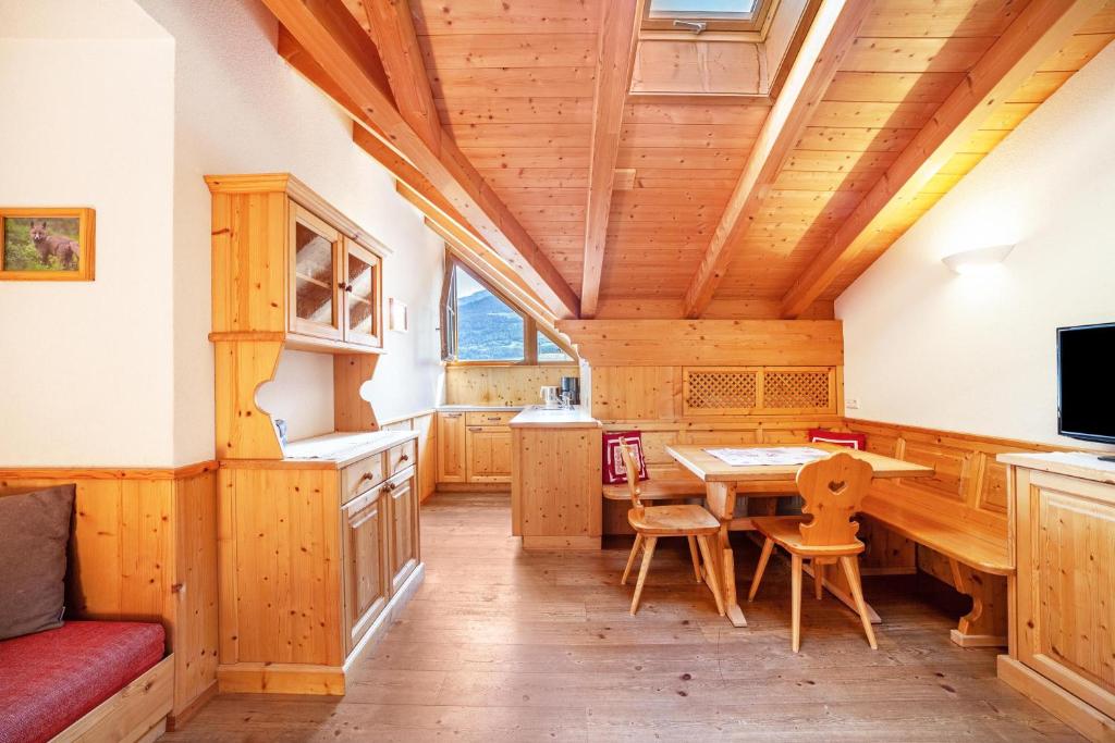 MontechiaroHof am Schloss Apartement Zirm的一间厨房和带木制天花板的用餐室