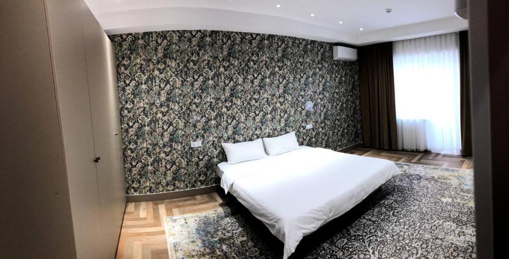 塔什干Tashkent City View Apart的卧室配有白色的床和墙壁