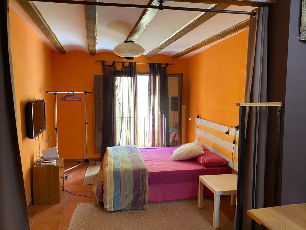 赫里卡Cuatro Rosas Jerica的一间设有床铺的卧室,位于一个拥有橙色墙壁的房间