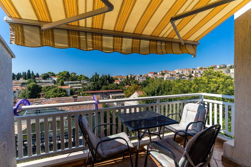 杜布罗夫尼克赫尔沃耶王子公寓酒店的阳台配有桌椅,享有风景。