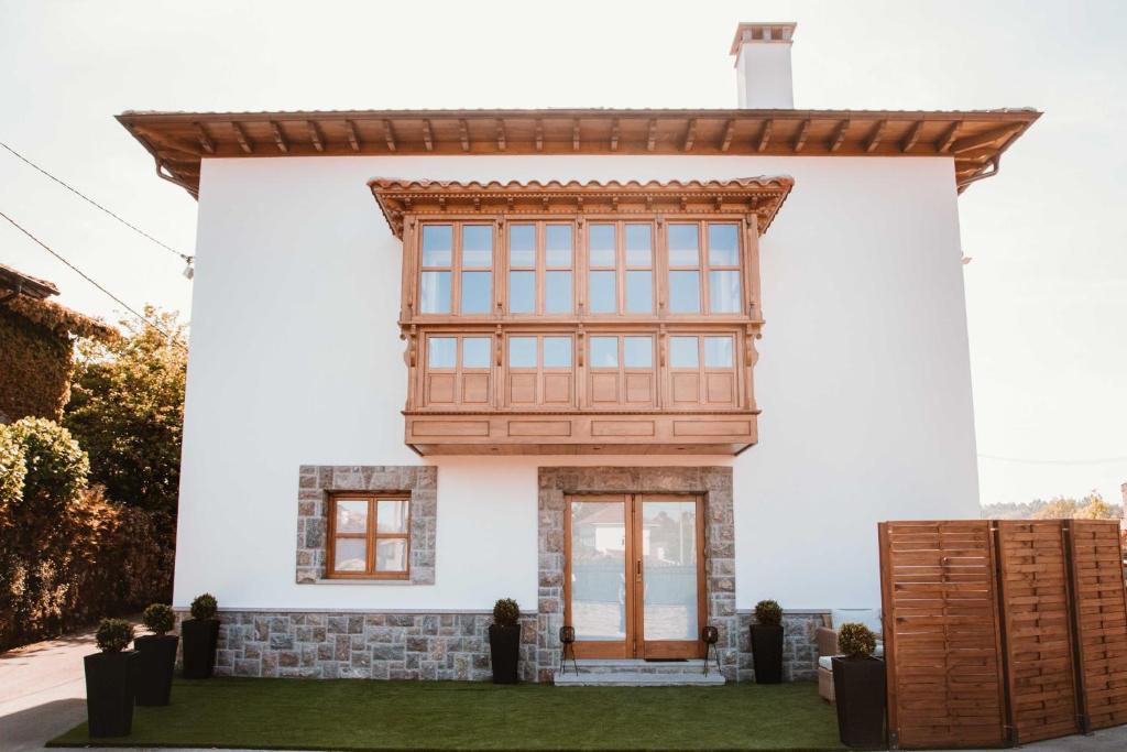 BalmoriEl Riveru - Astur Casas Rurales的白色的房子,设有木门和窗户