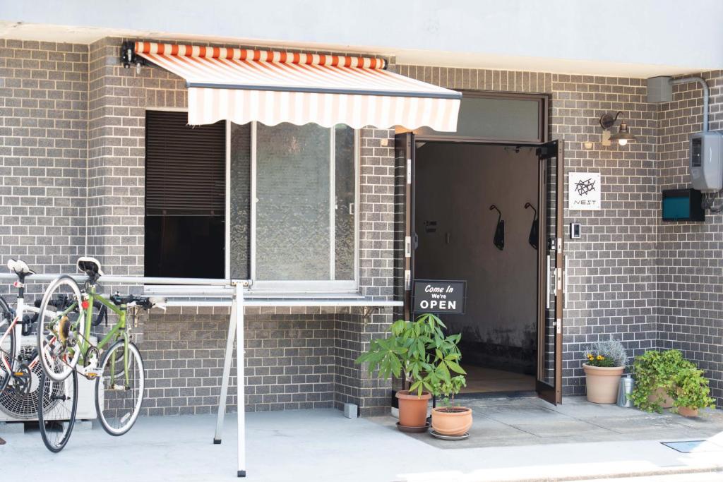 尾道市島宿Nest的一辆自行车停在一座带雨伞的建筑旁边