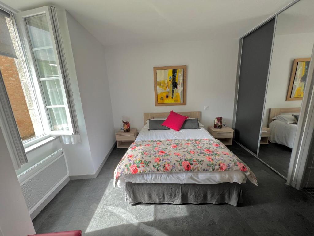 罗卡马杜尔Les pirondeaux的一间卧室配有一张带红色枕头的大床