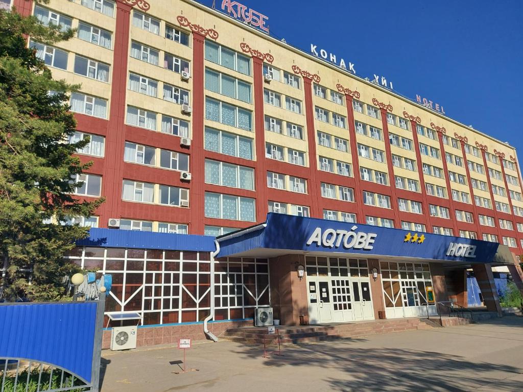 阿克托比Aktobe Hotel的一座大型红色建筑,与酒店同建