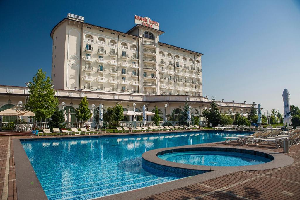 克卢日-纳波卡意大利圆山酒店的大楼前设有游泳池的酒店