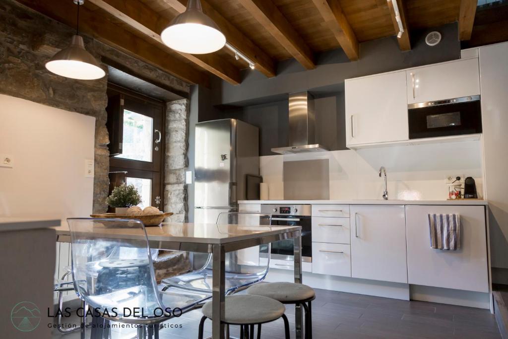 普罗阿萨El Torreón - Las Casas del Oso的厨房配有白色橱柜、桌子和凳子