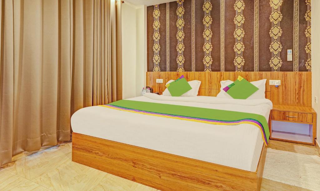 勒克瑙Treebo Trend Silver Stallion的卧室配有带绿色枕头的大型白色床