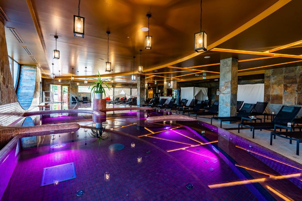 埃格尔Allure Healthy Hotel & Spa的一座建筑中一座带紫色灯光的游泳池