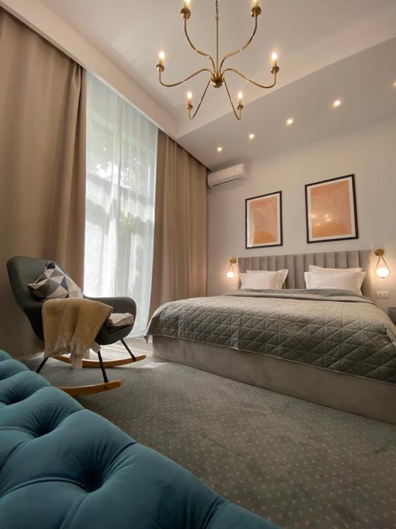 康斯坦察Cozy Flat 5的一间卧室配有一张床、一把椅子和一个吊灯。