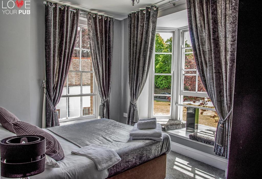 Rowlands Castle罗宾汉宾馆的一间卧室设有一张床和一个大窗户