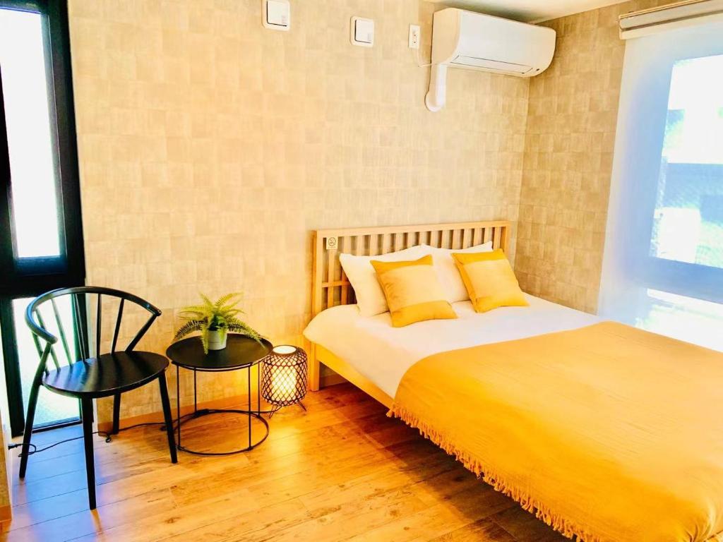 东京TIME SHARING STAY Ikebukuro的一间卧室配有一张带黄色枕头和椅子的床