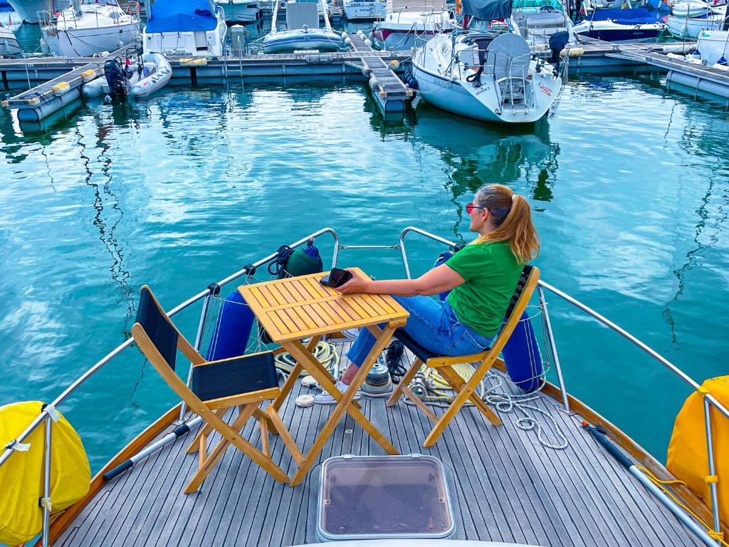 阿尔布费拉Stay in a Yacht - Algarve的坐在船尾桌子上的女人