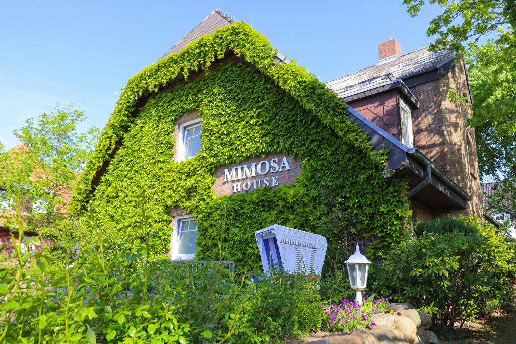 韦斯特兰Mimosa House的常春藤覆盖的房屋,上面有标志