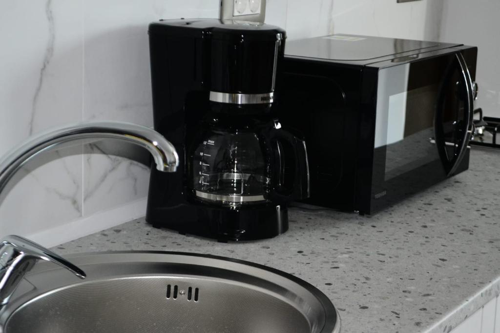 那沃达利Studiou Andu Nord 10 by Alezzi的厨房柜台配有咖啡壶和水槽