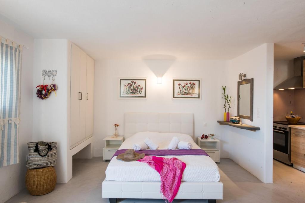 圣斯特凡诺斯mykonos 1001的卧室配有白色的床和粉色毯子