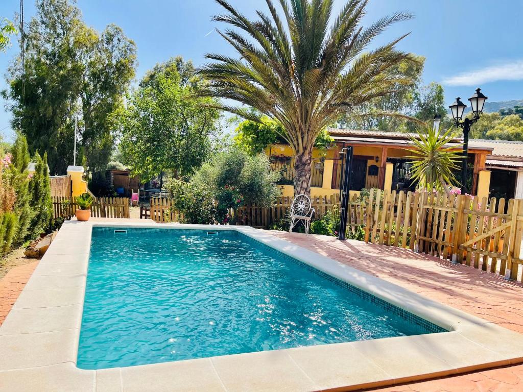 马拉加Cortijo el Alcornocal的一座房子旁的院子内的游泳池
