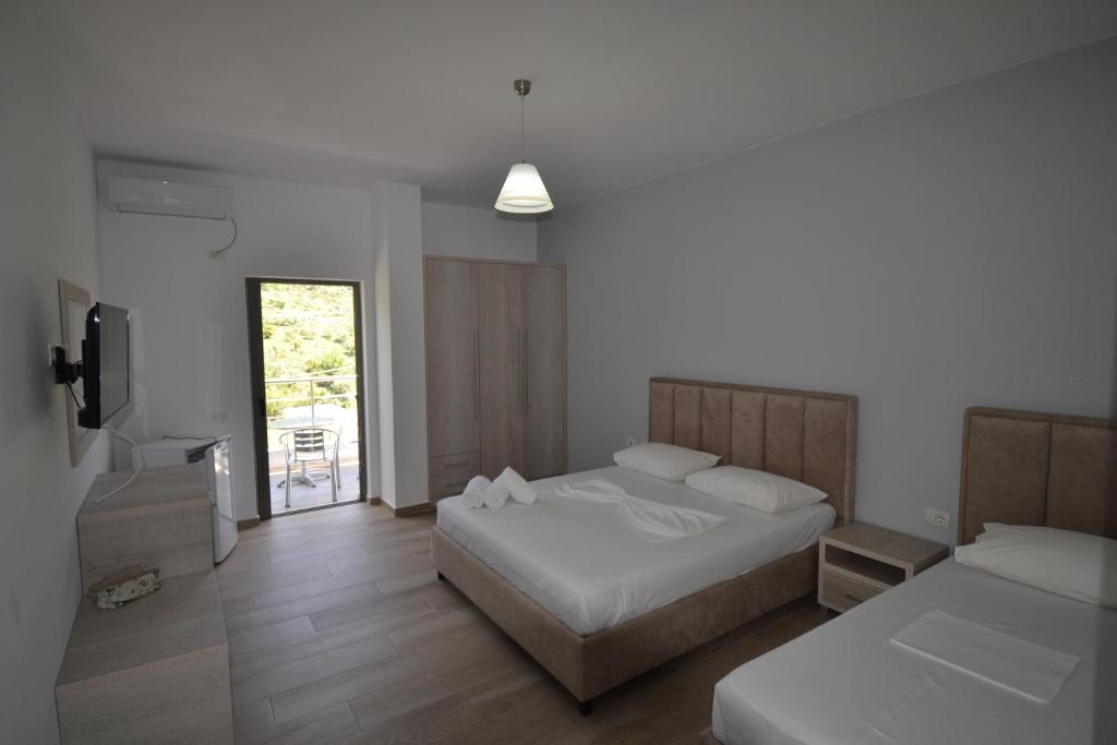 希马拉Bujtina Eleni的一间卧室配有两张床和电视。