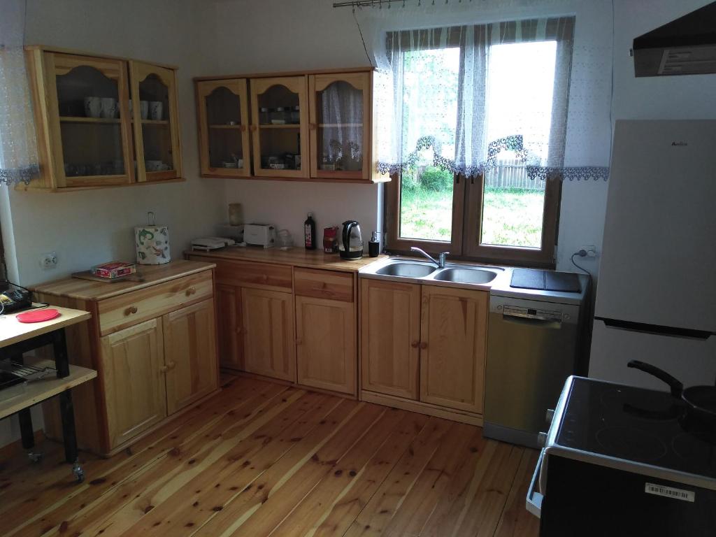 Zatorydom drewniany pod lasem的铺有木地板的厨房,配有木制橱柜。