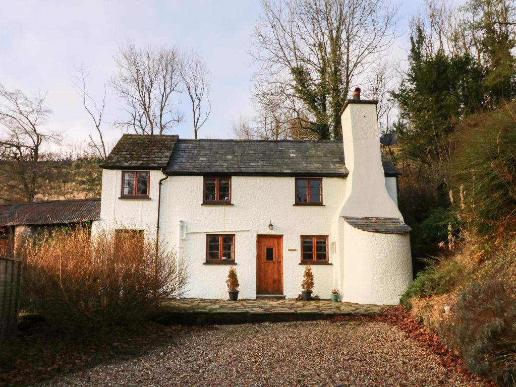 曼海德Hedgehog Cottage的山坡上带红色门的白色小屋