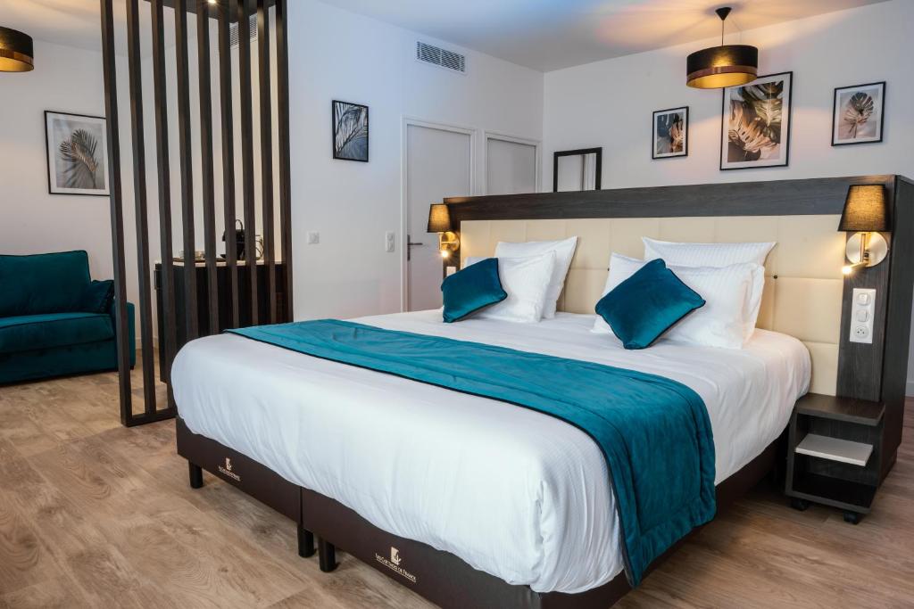 圣马尔Cottages de France CDG的一间卧室配有一张大床和一张蓝色椅子