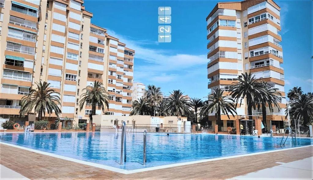 阿尔加罗沃Bonito Apartamento en Algarrobo-Costa的两个高楼前的大型游泳池