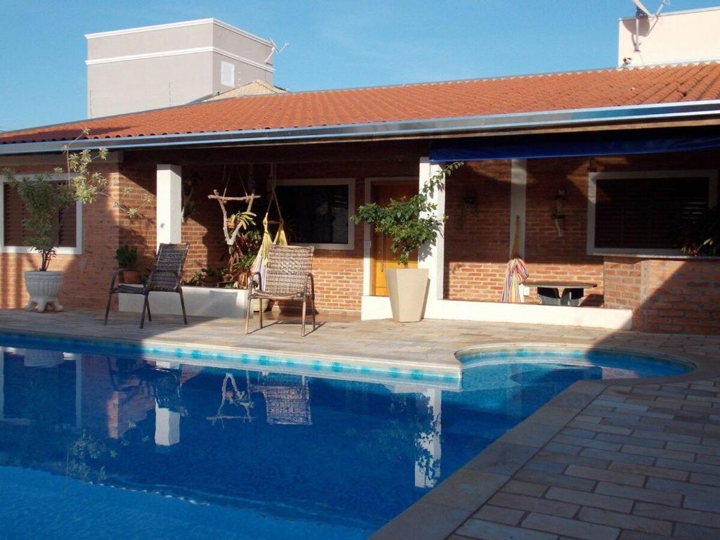 布罗塔斯Cantinho rústico simples & aconchegante的房屋前的游泳池