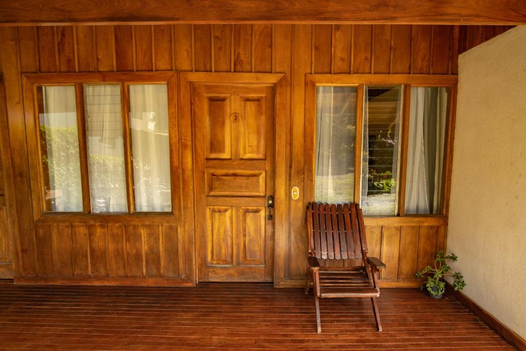 蒙泰韦尔德哥斯达黎加Cowboy Hostel - Habitaciones con Baño Privado的木门前的椅子