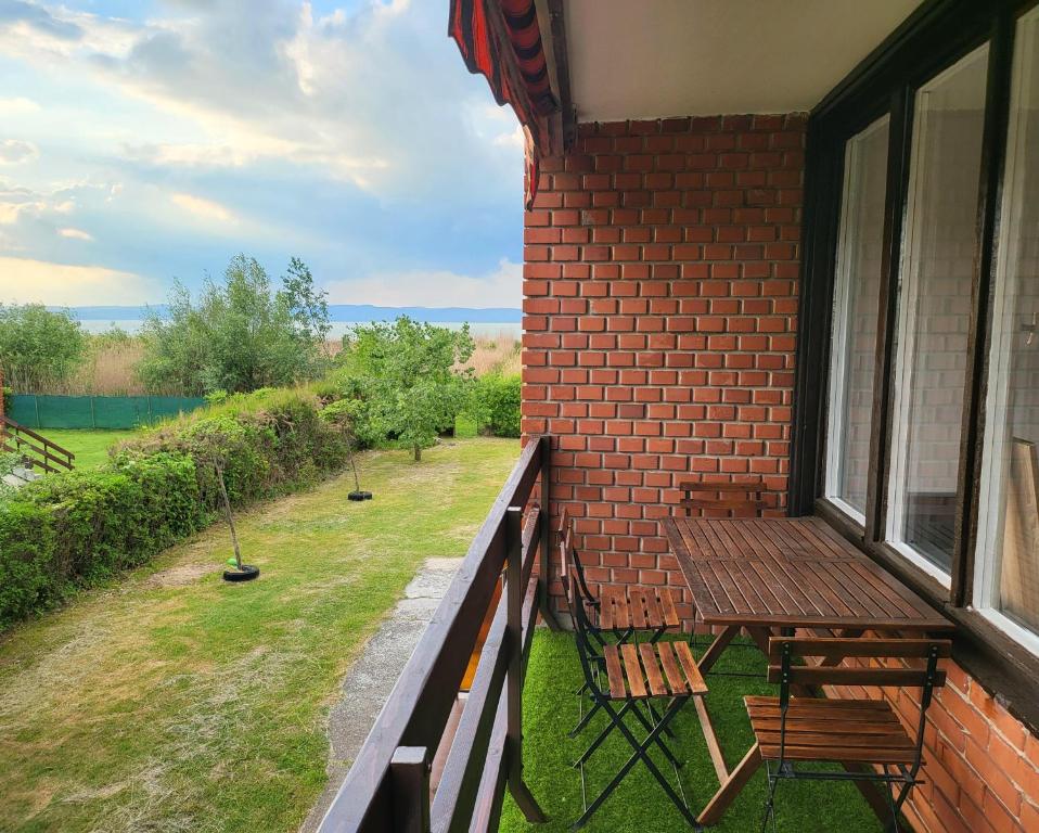 扎马迪Balatonic apartman的阳台配有两把椅子和一张桌子,还有一个窗户。