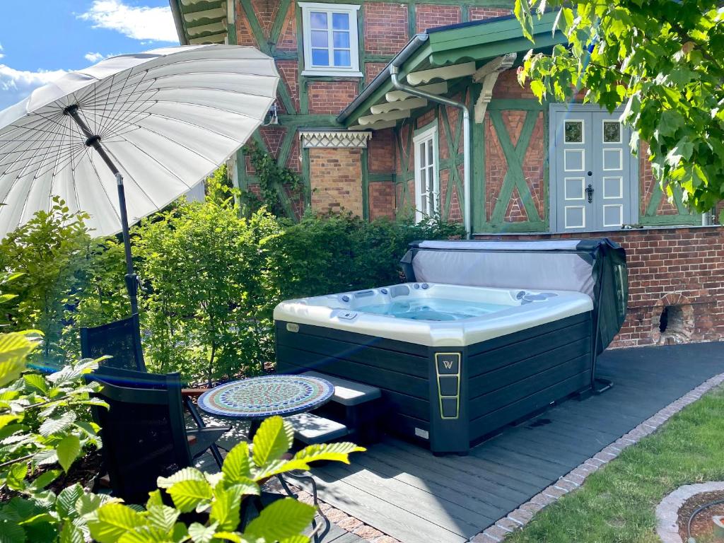 费茨肖Villa B das zauberhafte Chalet的后院的热水浴池,配有遮阳伞