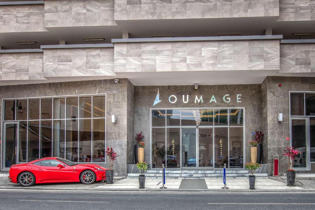 麦纳麦Loumage Suites and Spa的停在商店前的红色汽车