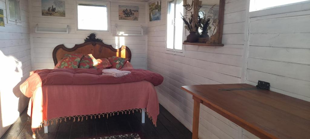圣安东尼奥德阿雷科Los furgones de Areco的一间卧室配有一张带红色毯子的床