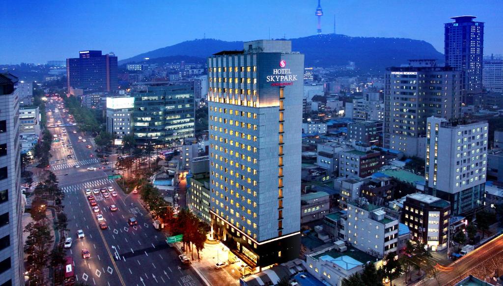 首尔天空花园酒店东大门1号店的一座高大的建筑,上面有城市的标志