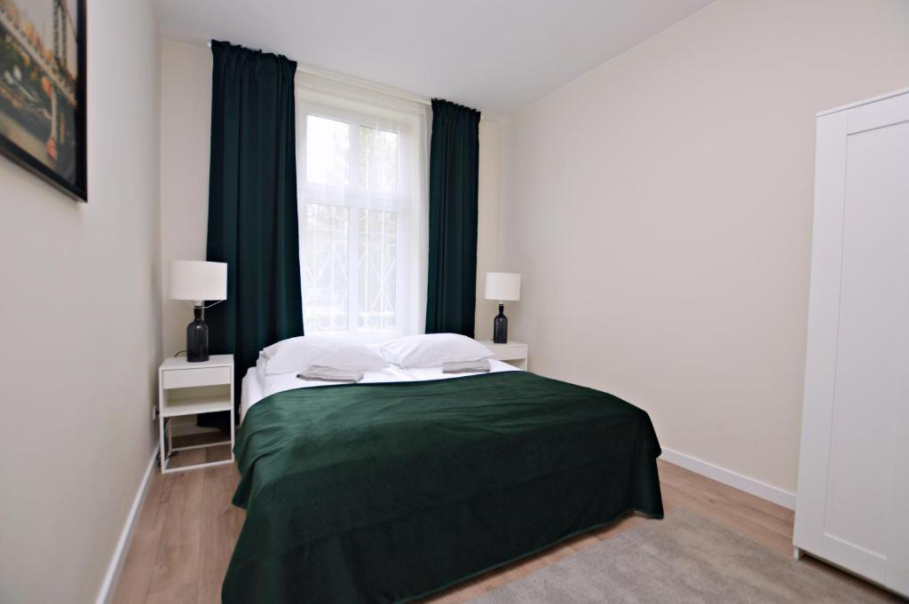 索波特Helska By the Sea的一间卧室设有一张绿色的床和一个窗户。