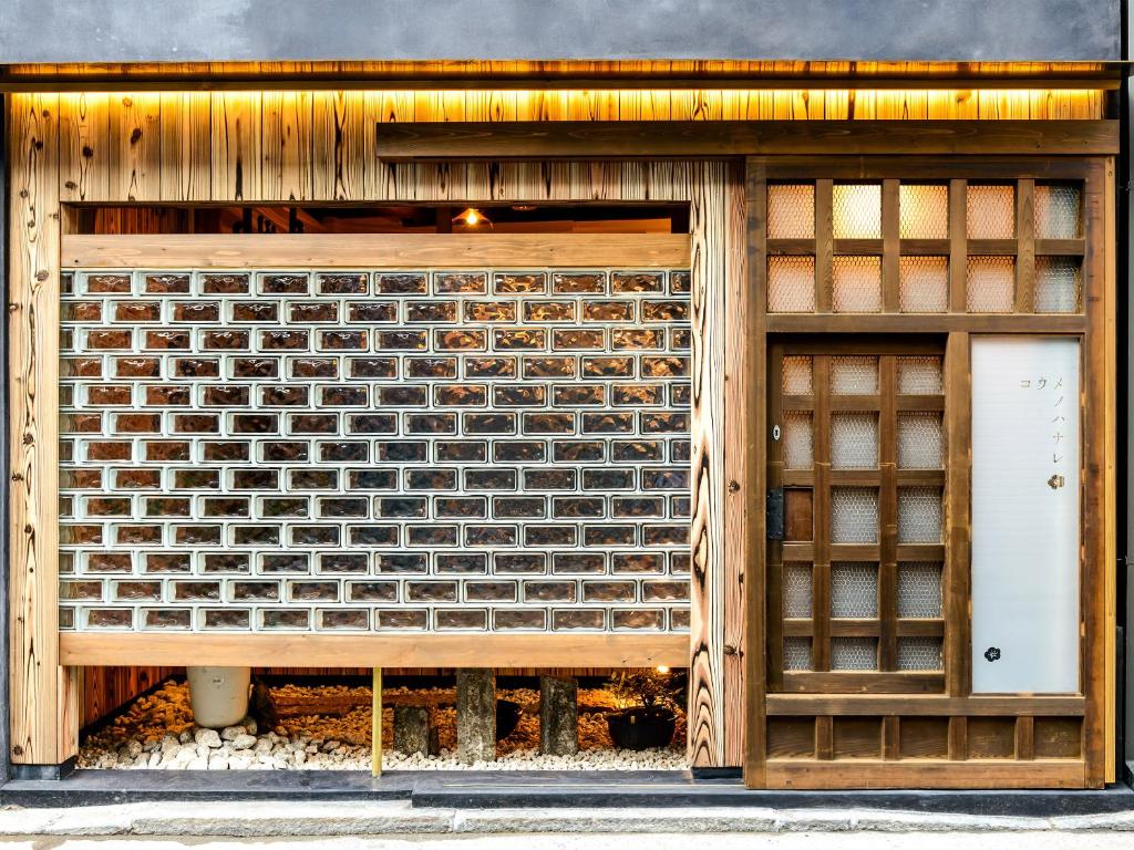 京都Koume no Hanare コウメノハナレ的砖砌建筑的窗口,有白色门