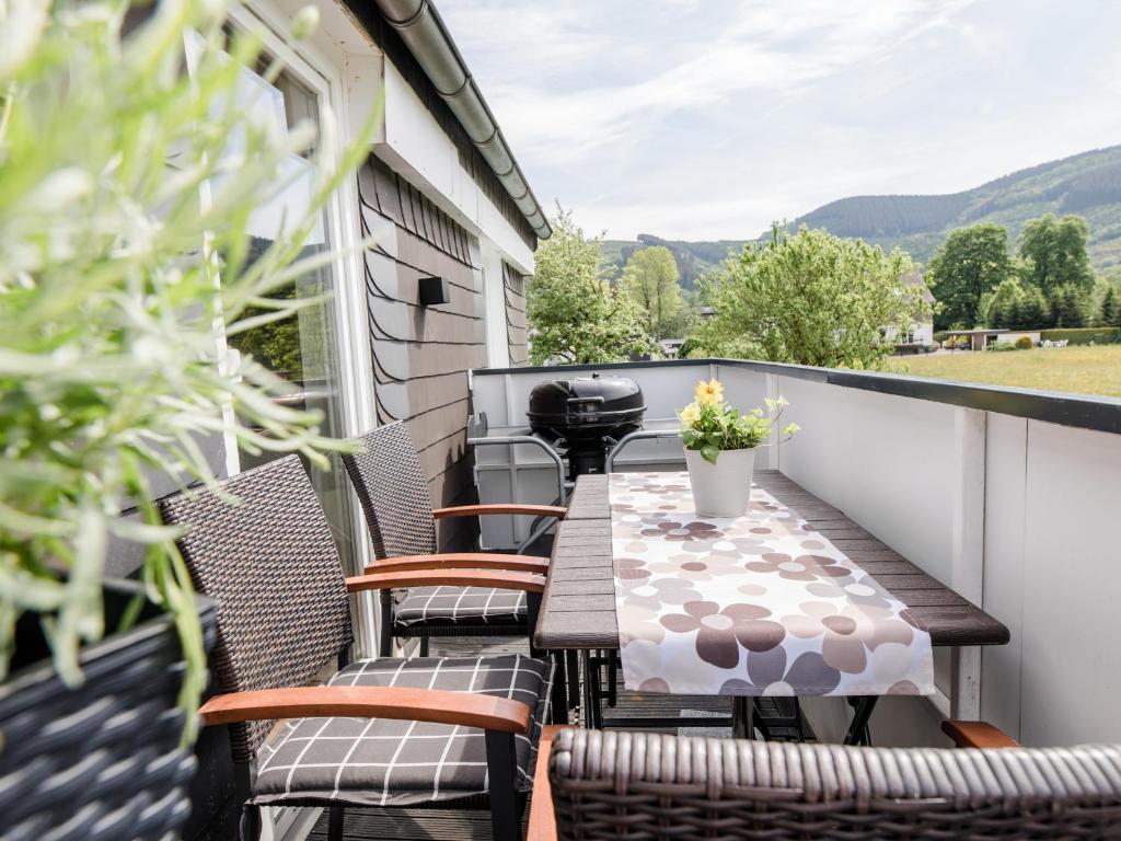 伦讷施塔特Ferienwohnung Kurparkblick Sauerland的阳台配有桌椅,享有山景。