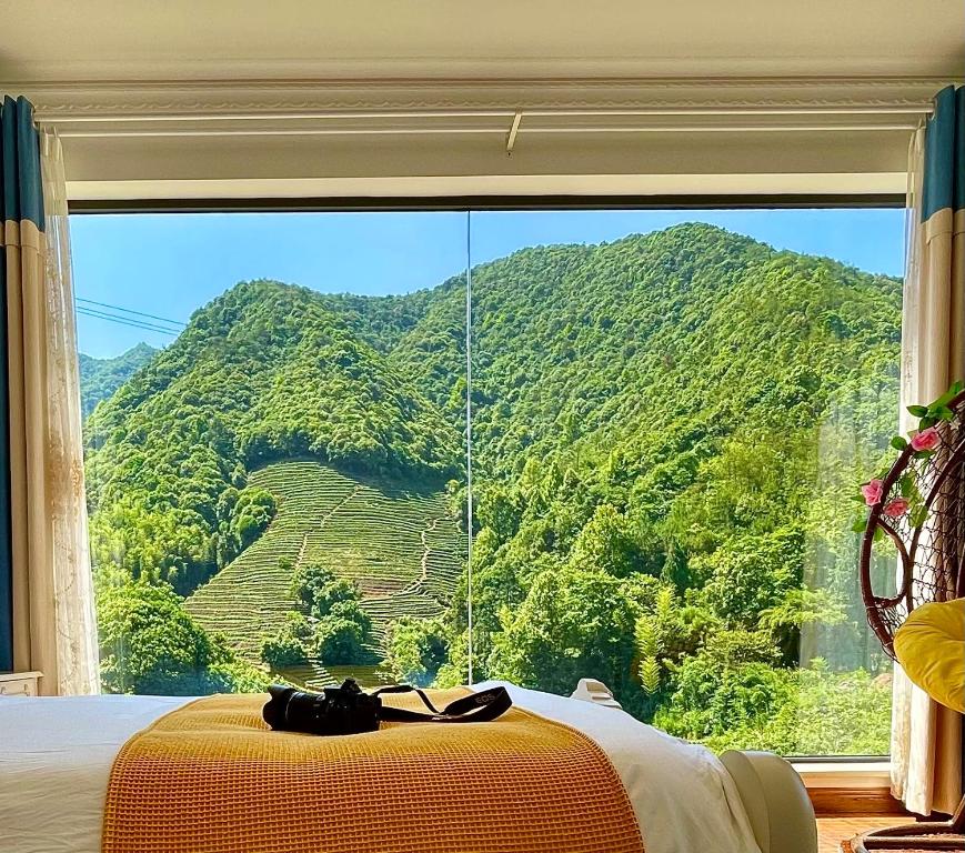 Liyang千岛湖月下民宿的卧室设有山景大窗户