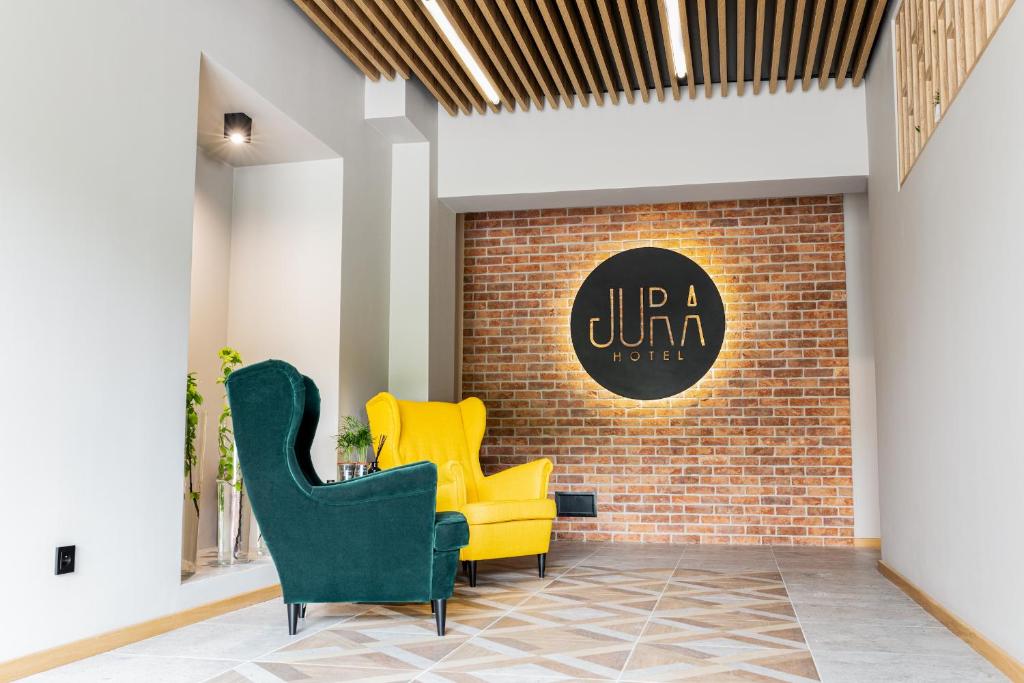 奥尔库什Jura Hotel Osiek的大堂设有2把黄色椅子和砖墙