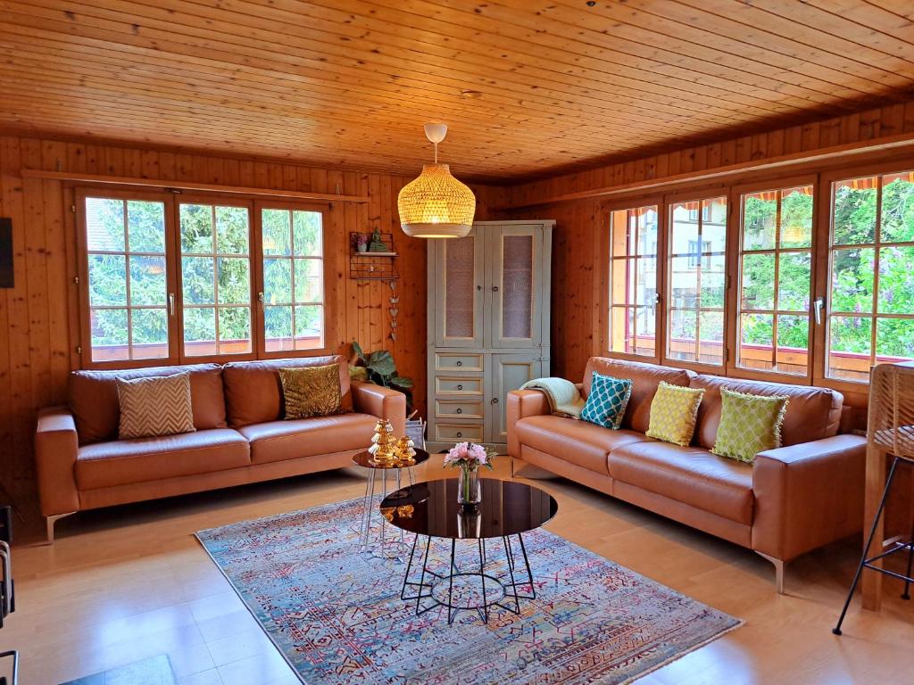 维尔德斯韦尔Sawasdee Swiss Chalet Wilderswil的客厅配有两张沙发和一张桌子