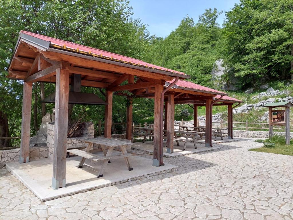 San Biagio SaracinescoLe Tre Dimore - Rifugio Aceroni的一个带长椅和野餐桌的木制凉亭