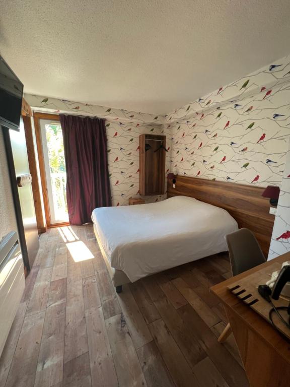 香槟沙隆Cit'Hotel Le Montreal的卧室配有一张白色大床和一张书桌