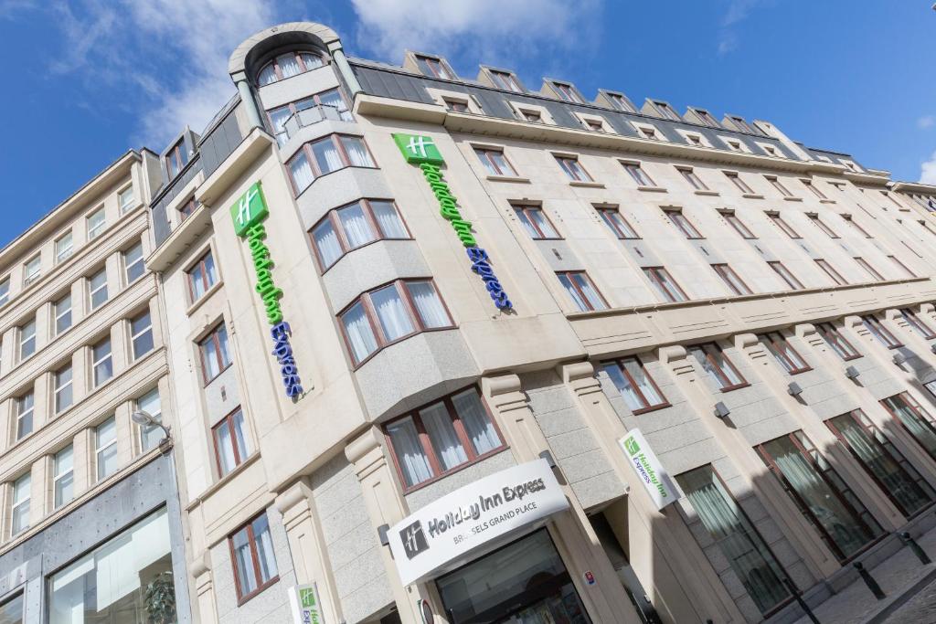 布鲁塞尔Holiday Inn Express Brussels-Grand-Place, an IHG Hotel的一座棕褐色的建筑,上面有绿色的字眼