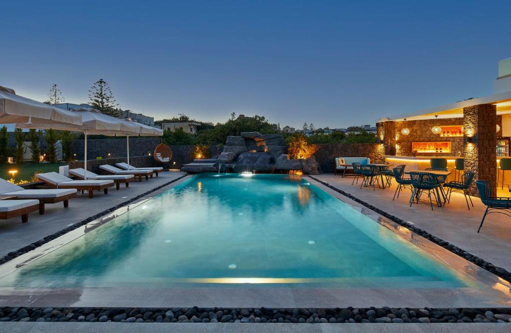 卡马利Mountain and Sea Suites的一个带躺椅的游泳池和一个庭院