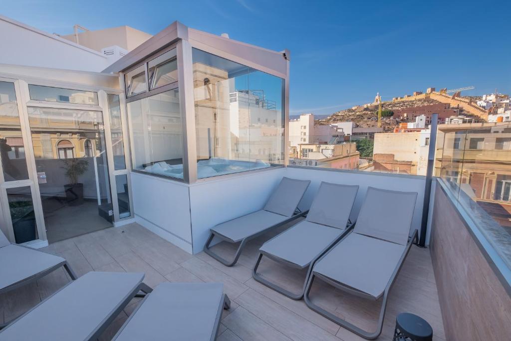 阿尔么丽亚努埃沃托雷卢兹酒店的阳台配有白色家具,享有城市美景。