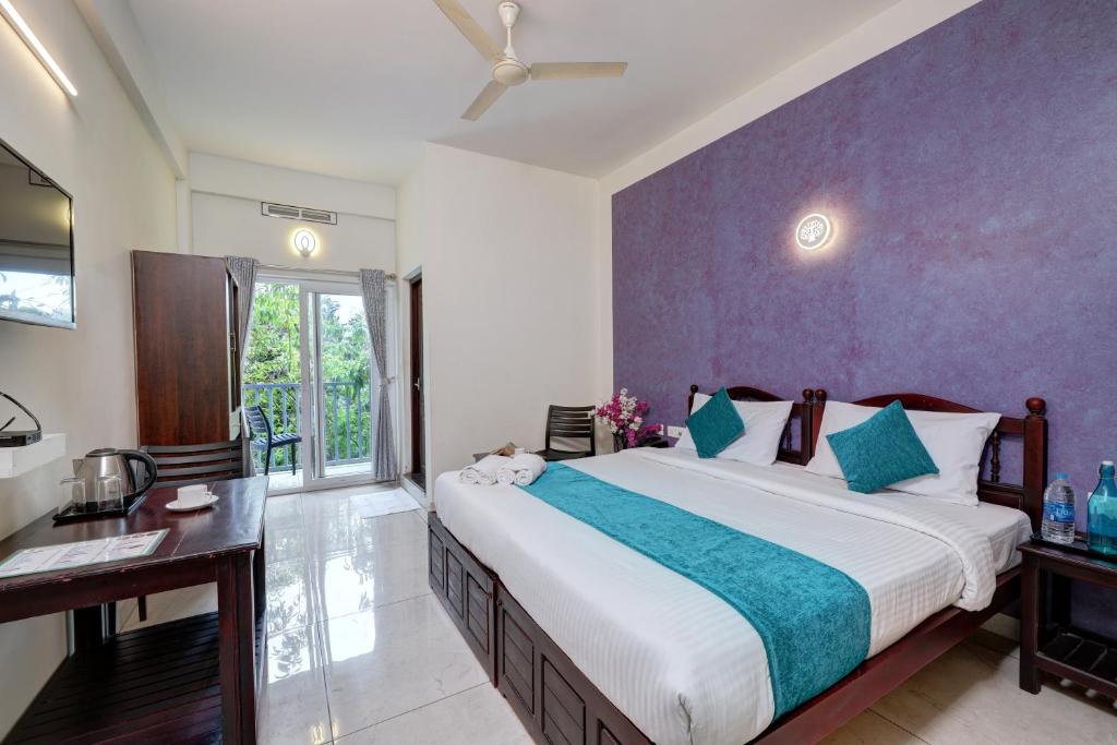 蒙纳Kurinji Wanderlust Resort Munnar的一间卧室配有一张大床和一张书桌