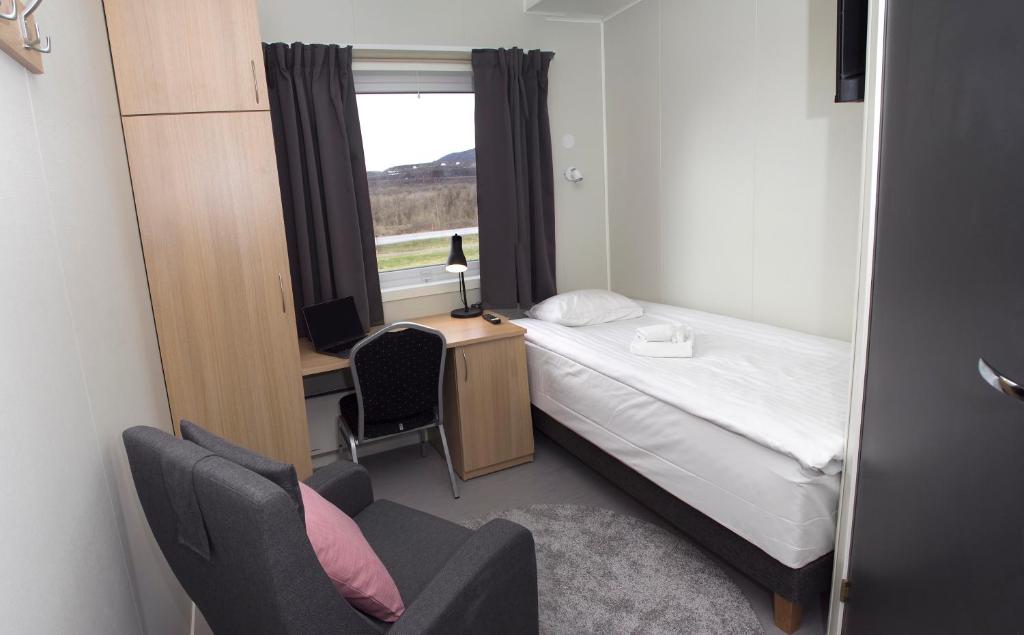 基律纳Kiruna City Room的一间卧室配有一张床、一张书桌和一个窗户。